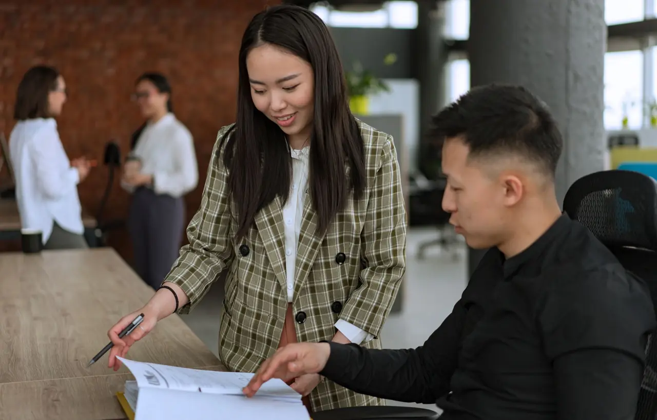 Two Quarterday accountants checking a client's papers together at a desk