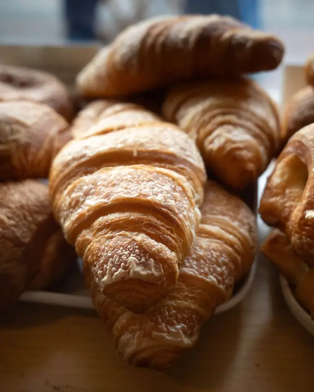 Golden, flaky butter croissants piled on the counter