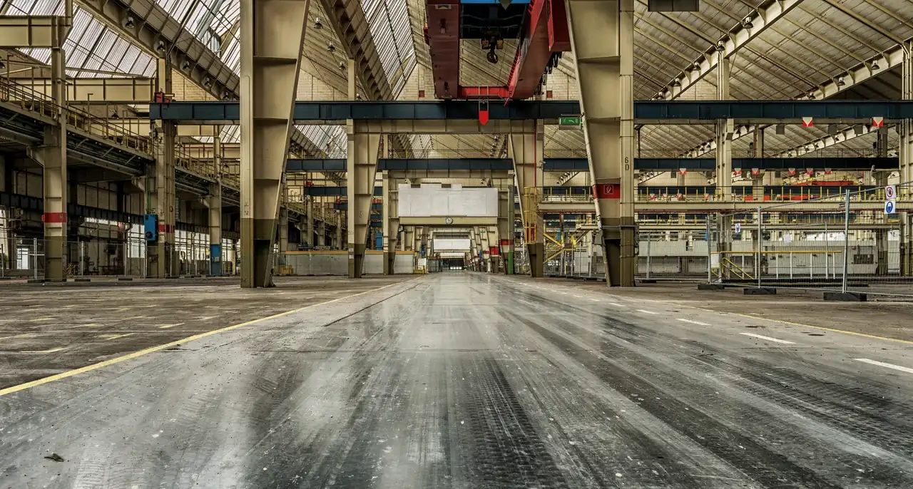Long industrial hall with steel portal frames and a polished concrete floor