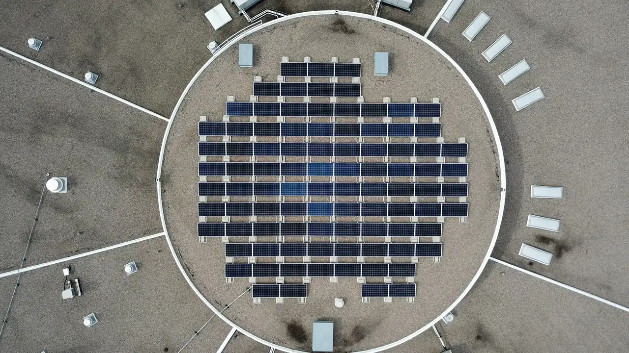 Aerial view of a round bank of solar panels on a warehouse roof