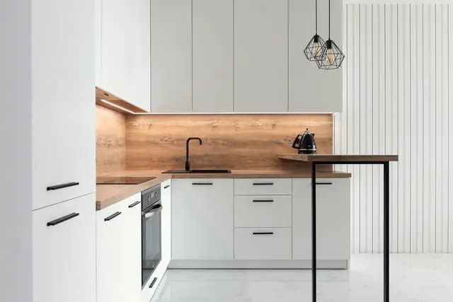 Punggol kitchen with matt white cabinets, a warm wood-look backsplash, black fittings and a slim breakfast counter