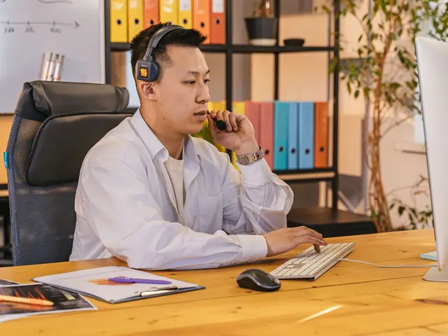 Daniel, Keelgrid's helpdesk lead, on a call at his desk in the Ubi office