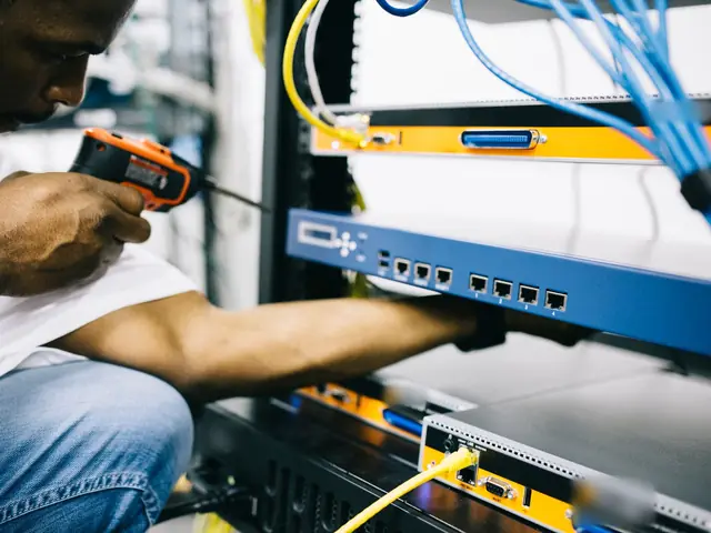 An engineer testing a port on the client's firewall with a handheld network tester