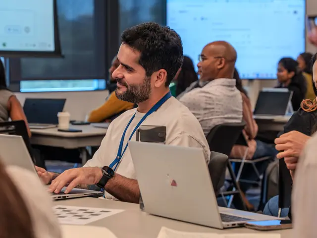 A small group of office staff at laptops during a short security refresher session