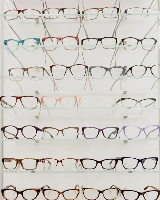 Rows of acetate and metal glasses on glass shelves in an optical shop