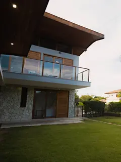 A corner terrace house with a timber upper floor and palm trees