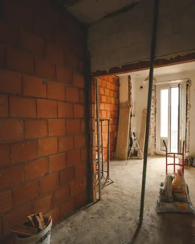A gutted room with bare brick walls and rubble on the floor