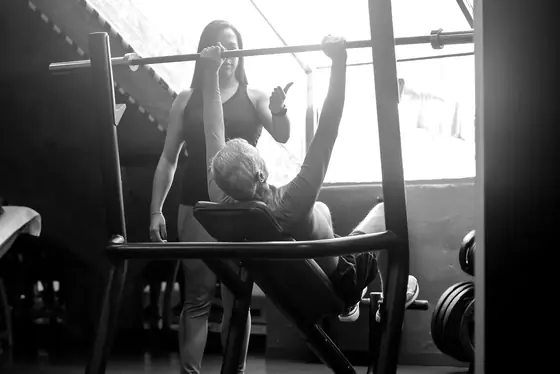Corinne guides a member through a bench press