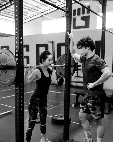 Joel spots a member's back squat in the rack