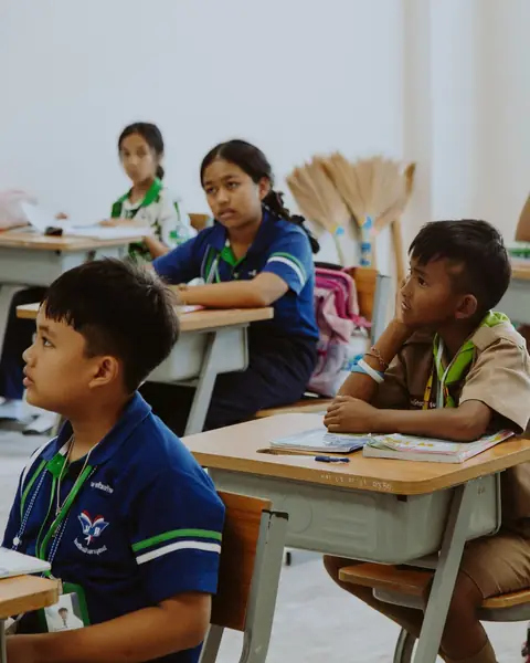 Lower secondary students at their desks, listening during a lesson