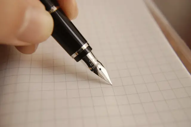 A fountain pen writing on squared paper